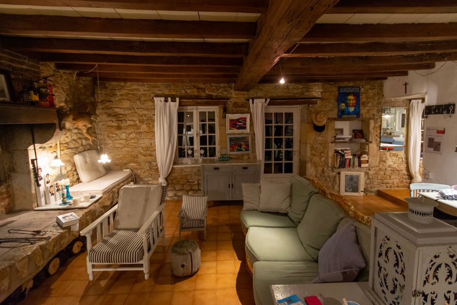 Soggiorno di un casale umbro con illuminazione calda e soffitti in legno